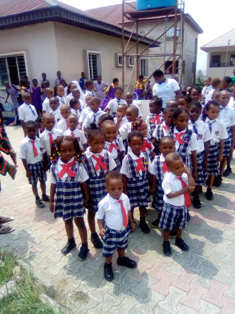 Children waving during an outdoor gathering